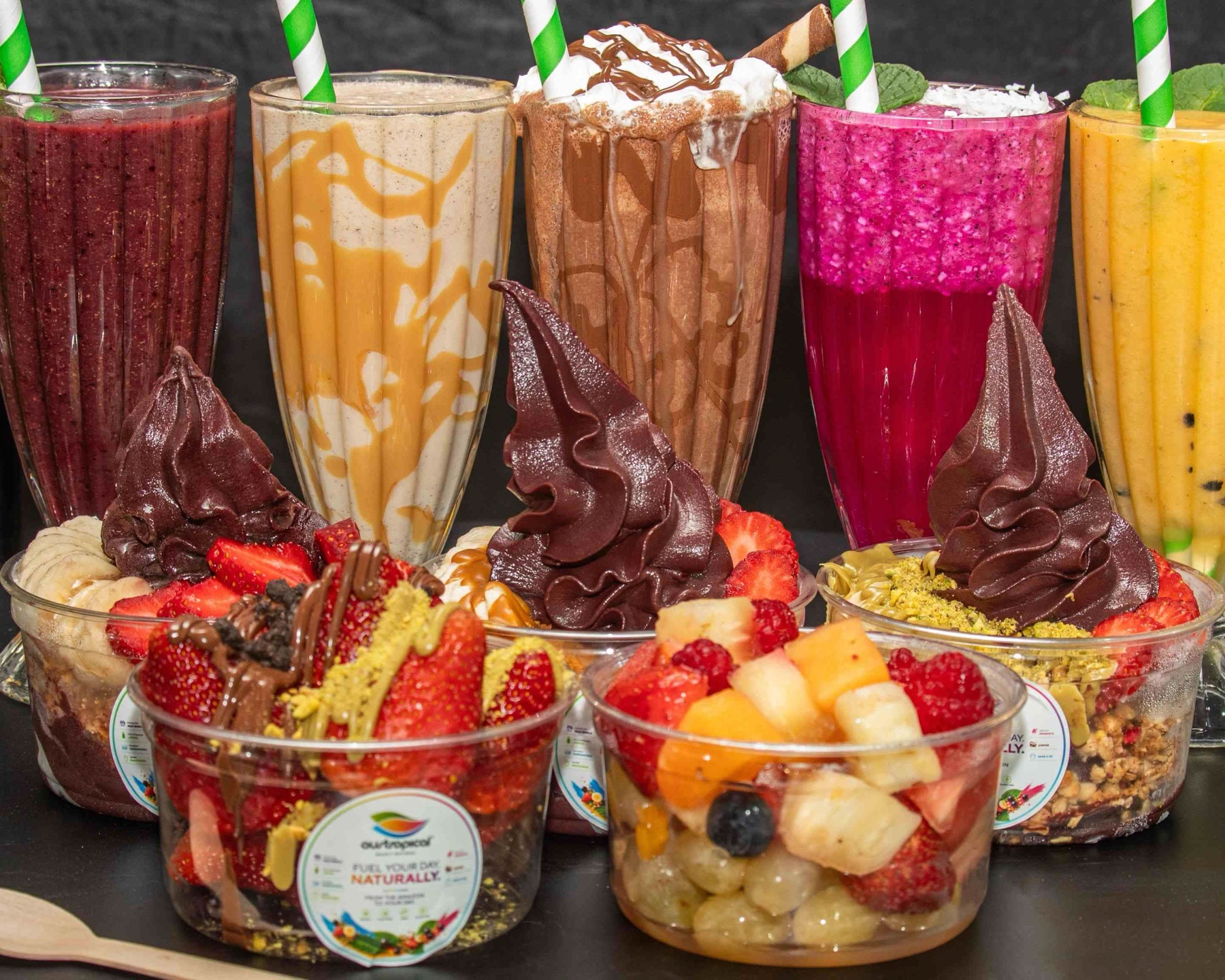 Smoothies, milkshakes, soft serve açaí bowls and fruit cups lined up on the counter